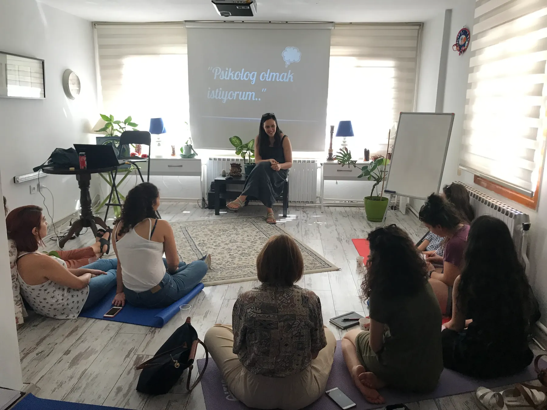 Bir grup çalışmasında katılımcılar minderlerde daire olmuş oturuyor